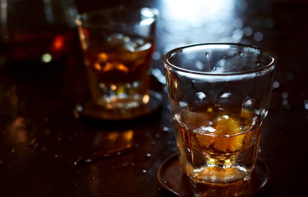 istock Glass of whiskey on wet table 1630447284