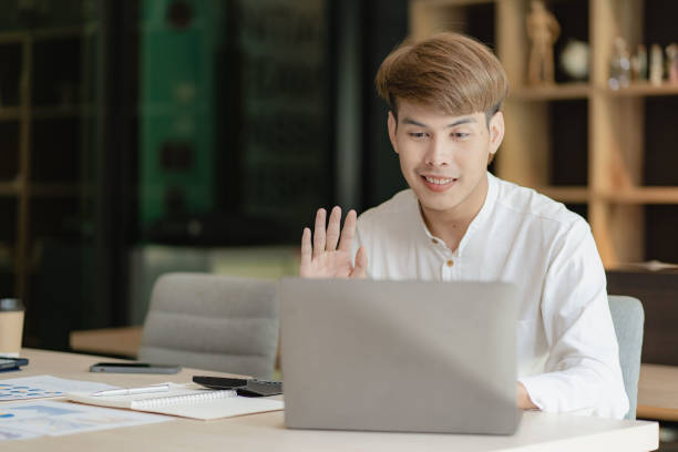 istock Asian young man doing accounting work using app and financial documents calculating salary of company employees and meeting online. 1630482103