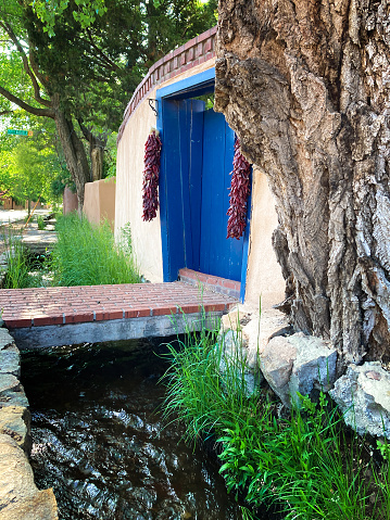 Santa Fe, NM: The Acequia Madre (Mother Ditch) flows past traditional blue doors in downtown Santa Fe.