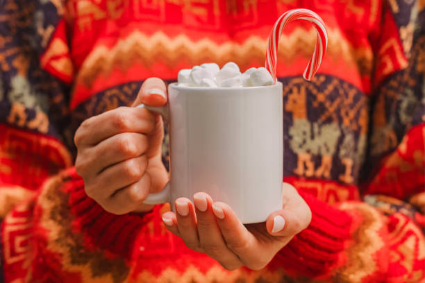 Woman in red sweater holding white cup with hot chocolate close-up. Christmas mug mock-up Woman in red sweater holding white cup with hot chocolate with marshmallow close-up. Christmas mug mock-up candy peppermint christmas mint stock pictures, royalty-free photos & images