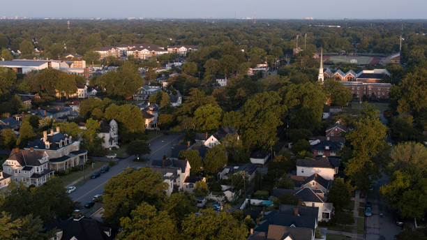 Dawn awakening in wealthy Residential District of Hampton, VA: Victoria Blvd comes alive under the sunrise, highlighting detached houses and churches. Aerial view Wealthy neighborhood streets in the early morning: Multi-story detached house and First Presbyterian Church on Victoria Blvd, Hampton, Virginia hampton virginia stock pictures, royalty-free photos & images