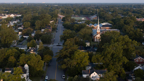istock Residential District under the sunrise beams, explore Victoria Blvd in Hampton, VA. Small Neighborhood street leading to horizon in early morning. Aerial view 1630659087