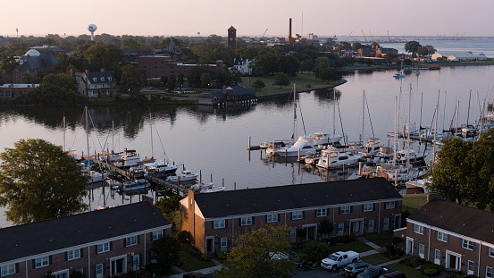 Sun rises over calm Pier, where yachts and boats moored near the shore of Salters Creek. Hampton River and the Phoebus coast in the distance in Hampton, Virginia
