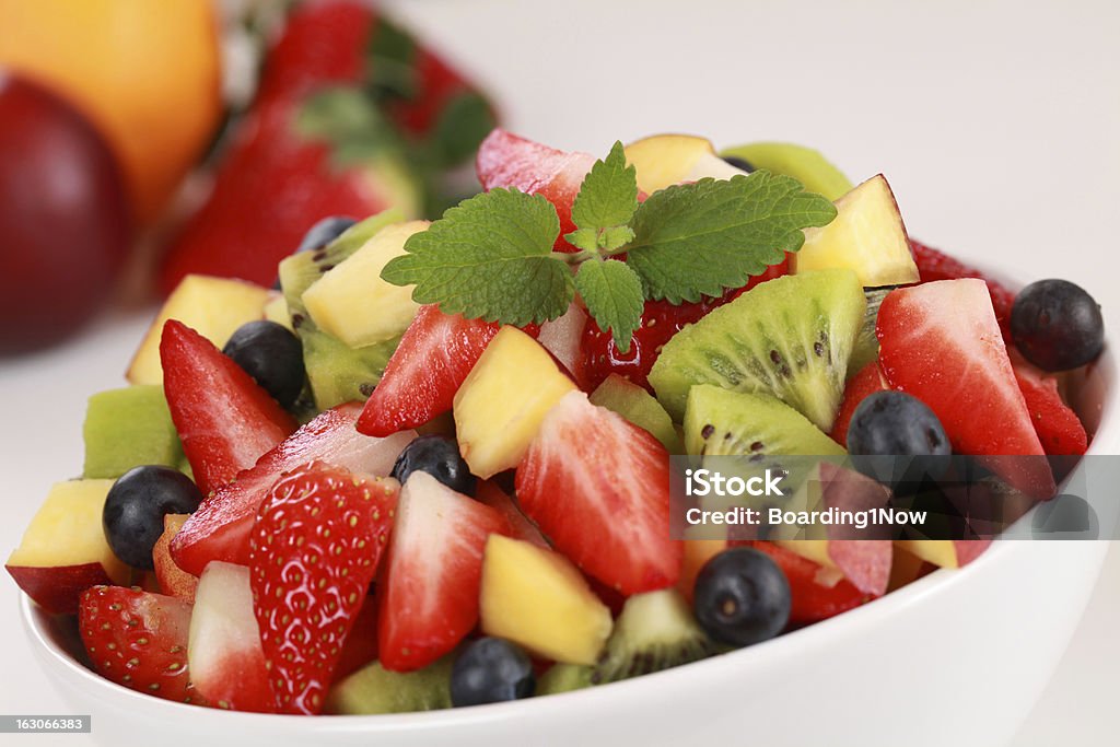 Fruit salad Fruit salad in a bowl with strawberries, kiwi, blueberries and peaches Berry Fruit Stock Photo