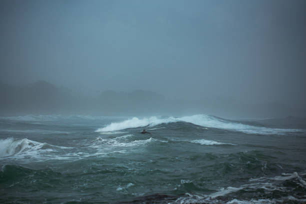 Watching the surf and surfers in Bicheno, on the coast of Eastern Tasmania on a rainy day during the on-season in October