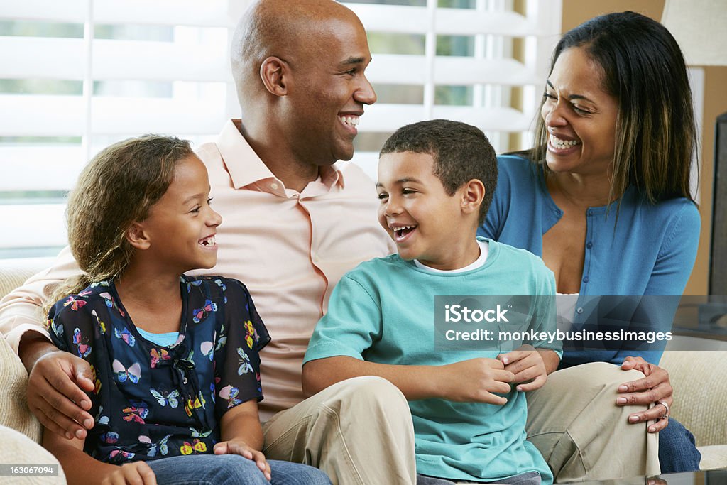 Rodzina siedzi na kanapie razem - Zbiór zdjęć royalty-free (Rodzina)