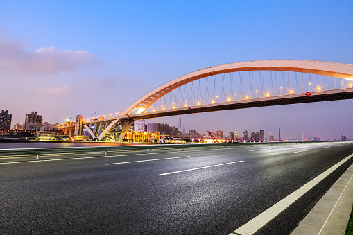 Asphalt highway and bridge with city skyline in Shanghai at night, China.