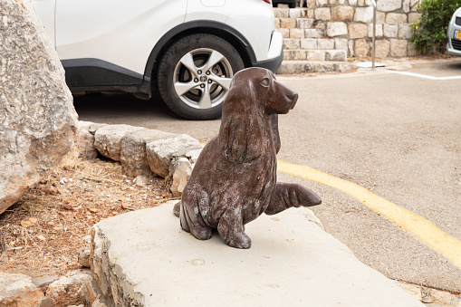 Haifa, Israel, June 03, 2023 : Stone statue of a dog raising its paw made by a local artist in the famous artists village Ein Hod near Haifa in northern Israel
