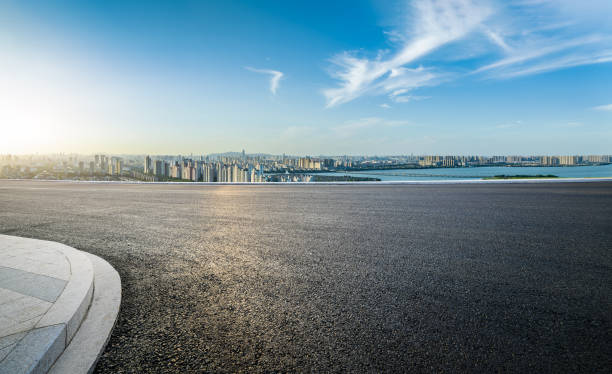 istock Asphalt road and urban skyline with sky clouds at sunset 1630737201