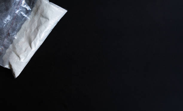 istock Cocaine in a plastic package on a black background. 1630738770