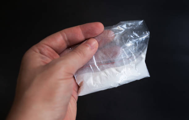 istock Cocaine in a plastic package on a black background. 1630738773