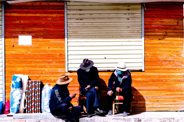 3 Chinese People Chatting in front of an abandoned shop in Qinghai