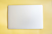 Top view of modern laptop isolated on yellow background.