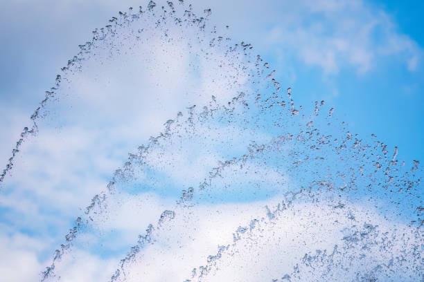 salpicaduras de agua contra el fondo azul del cielo - fountain water physical pressure splashing fotografías e imágenes de stock