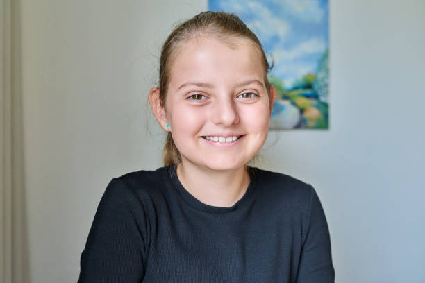 明るい壁の背景に10歳の少女のポートレート - 10 11 years child human face female ストックフォトと画像
