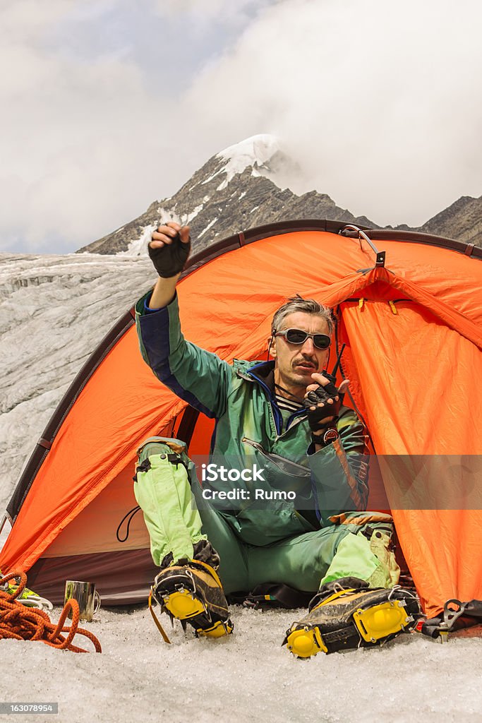 O alpinista em montanhas causas de ajuda - Foto de stock de Acampar royalty-free