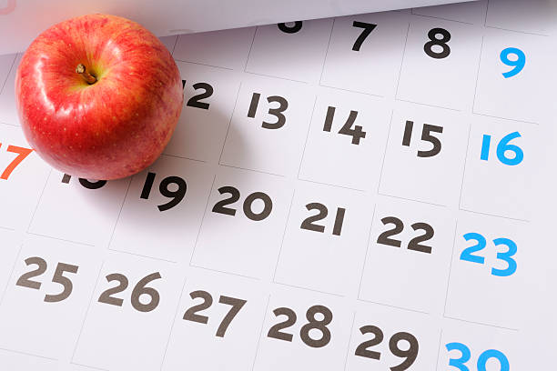 Red apple on calendar High angle view of red apple on calendar. Nutrition Week  stock pictures, royalty-free photos & images