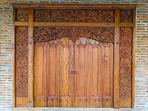 Wood carving the entrance door of traditional Javanese House called joglo
