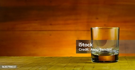 istock Empty glass on wooden table 1630798037