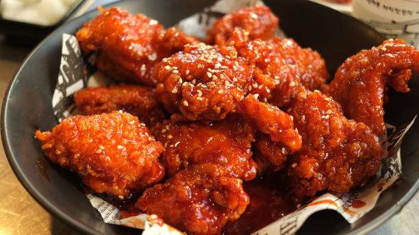 Soy and Spicy Korean fried chicken on a black plate.