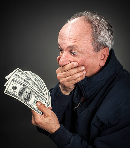 istock elderly man with fan of dollars 163081692