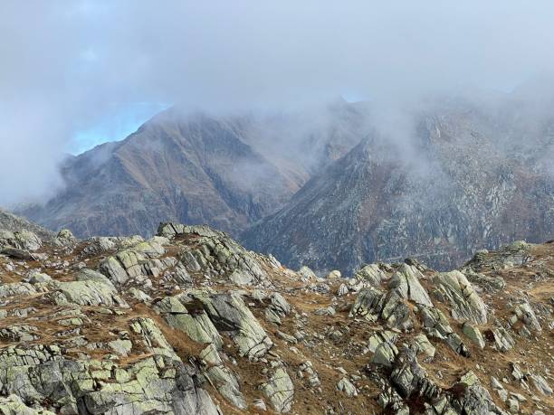 Mystical low autumn clouds and typical mountain fog in Swiss alpine area of St. Gotthard pass (Gotthardpass), Airolo - Canton of Ticino (Tessin), Switzerland (Schweiz) stock photo