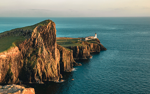 The view of the Neist Point Lighthouse and the Neist cliff on the west coast of the Isle of Skye in the sunset
