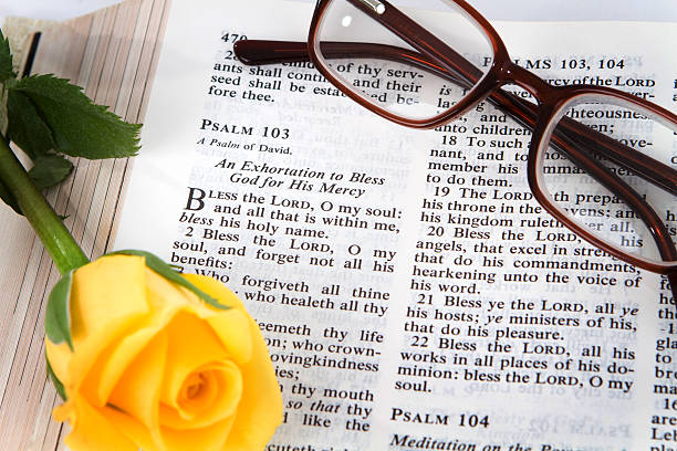 Psalms 103 Holy Bible opened to the book of Psalms chapter 103 with a yellow rose and reading glasses. psalms stock pictures, royalty-free photos & images