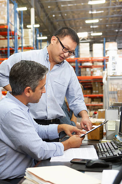 istock Business Colleagues Working At Desk In Warehouse 163087806