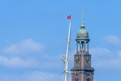 Low angel view of Church with sail mast against sky, Germany Hamburg harbor