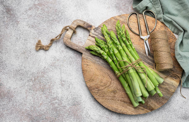 istock Fresh green asparagus on  concrete background. 1630936257