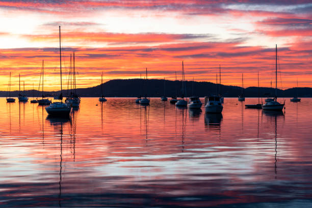 istock Sunrise over the water with boats, reflections and high cloud 1630953381