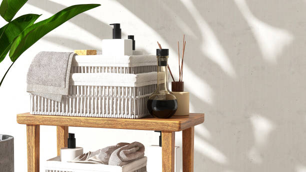 istock Wooden side table, white rattan basket with soap, shampoo, reed stick diffuser, towel, banana tree in sunlight 1630957235