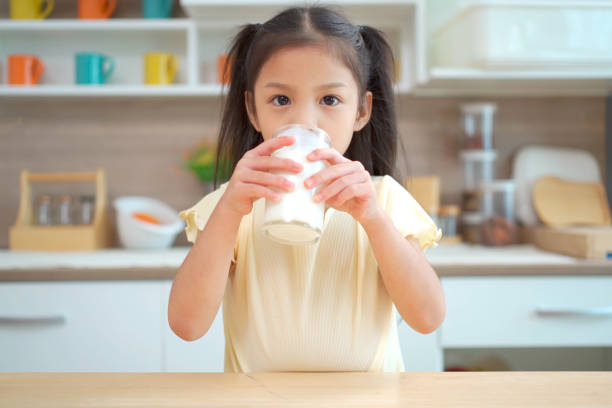 istock Little cute girl drinking a milk 1630960487