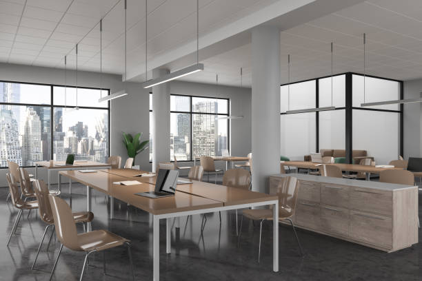 istock Stylish library interior with work table and chairs, lounge zone and window 1630980361