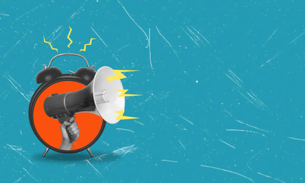 istock Art collage, hand holding a megaphone on a blue background with space for text and advertising. The hand emerges from an alarm clock. 1630995801