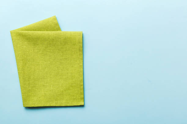 istock top view with green kitchen napkin isolated on table background. Folded cloth for mockup with copy space, Flat lay. Minimal style 1631002979