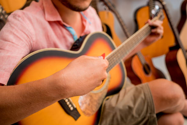 istock Young musician testing classical guitar in a guitar shop 1631023495