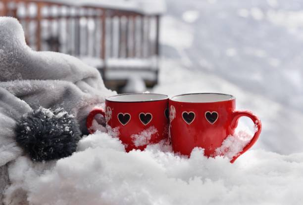 istock two red mugs with heart shaped on the snow and blanket 1631029970