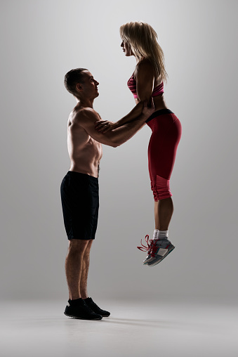 Young strong muscular man doing functional training with athletic woman