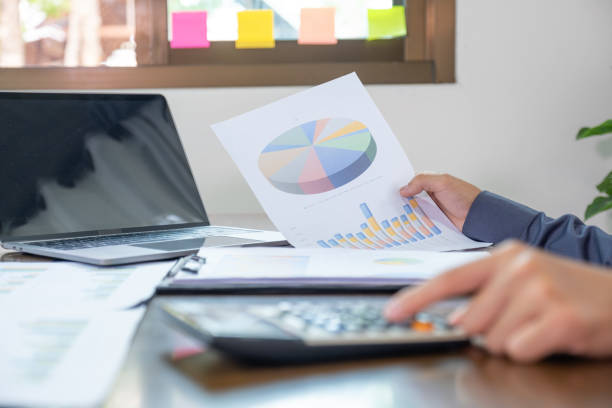 istock Businessmen bookkeeper hand holding graph, use calculator and laptop doing account for paying tax on white desk in working office 1631042507