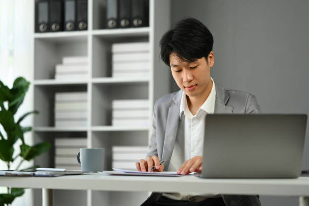 istock Businessman sitting at office desk working with startup project at modern office 1631057369