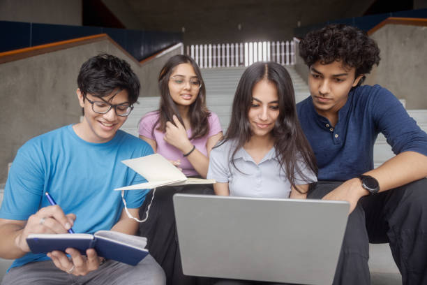 istock Indian college students sitting on stairs studying, working together 1631061201