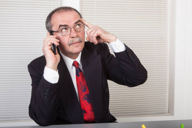 Senior businessman in office talking on the phone
