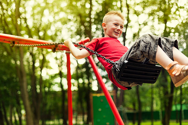 istock Cute boy swinging in a park 163107475