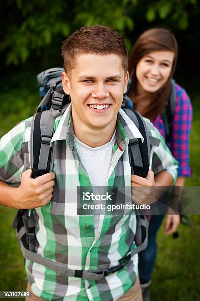 Young Couple Walking Through Forest Stock Photo - Download Image Now - 20-24 Years, 20-29 Years, Active Lifestyle