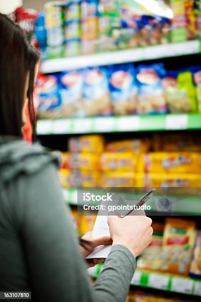 A Person Checks Off Their Shopping List In A Supermarket Stock Photo - Download Image Now