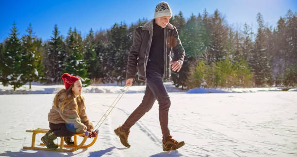 istock Granddaughter enjoying sledge ride with grandfather 1631081843