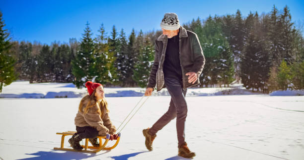 istock Granddaughter enjoying sledge ride with grandfather 1631081867