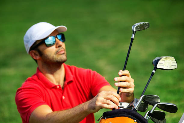 istock Young man taking choosing a club at a golf course driving range. 1631101652